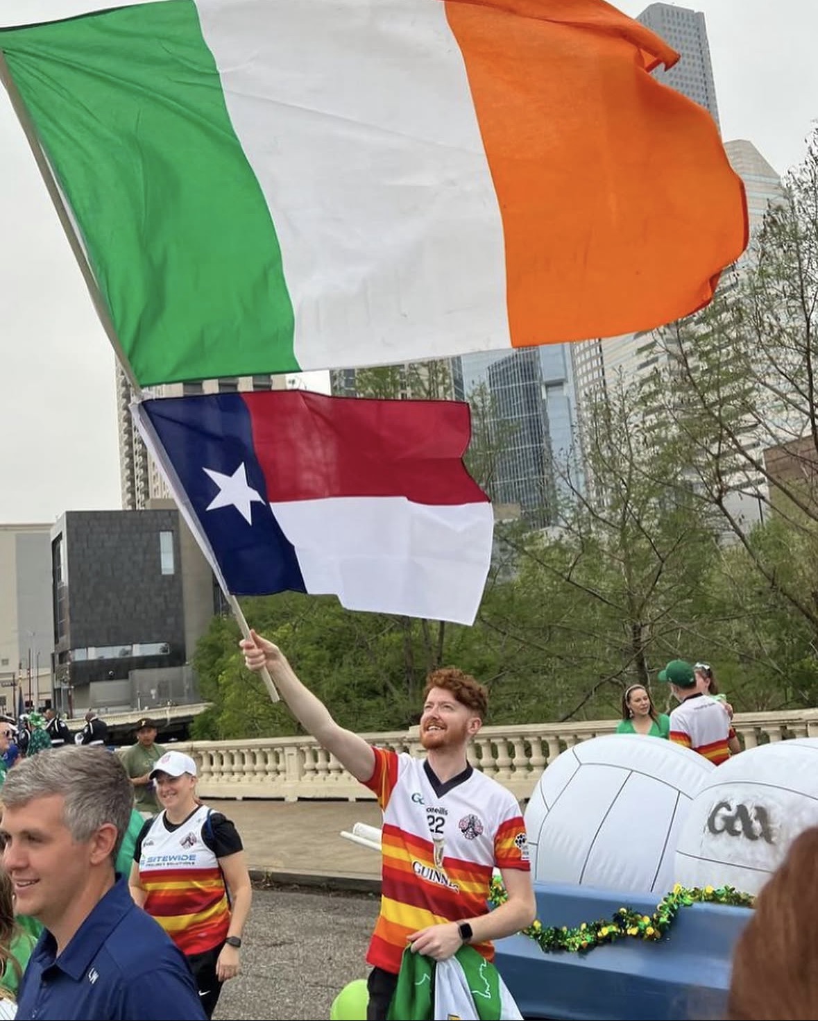 Jack in his jersey waving a texas and irish flag during parade